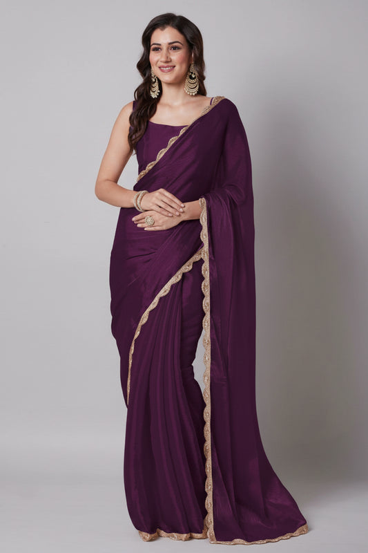 Woman wearing a purple saree with gold border on a beige background