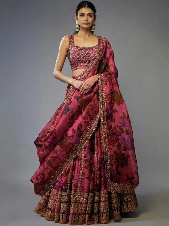 Woman wearing a traditional pink saree with floral patterns on a gray background