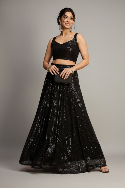 Woman wearing a black sequined outfit against a red background