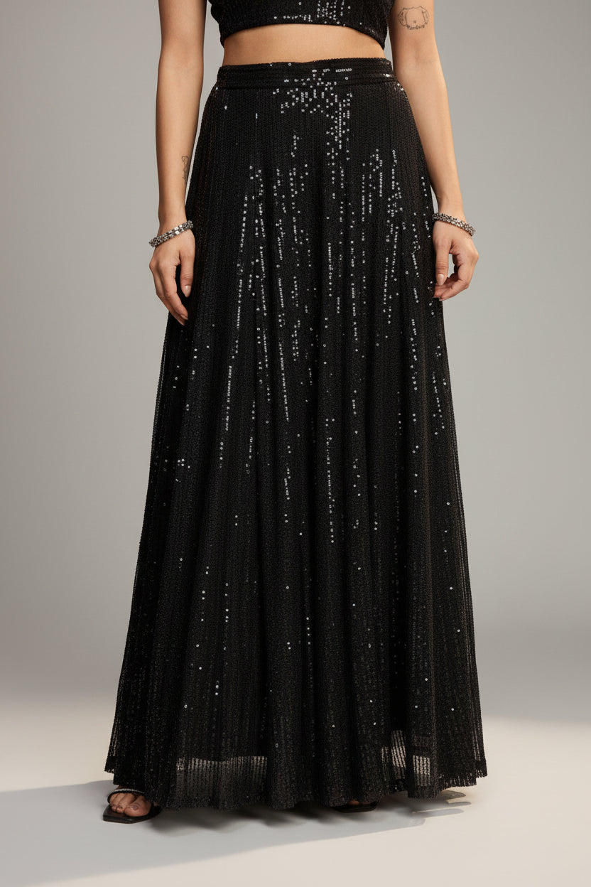 Person wearing a black sequin skirt against a red background