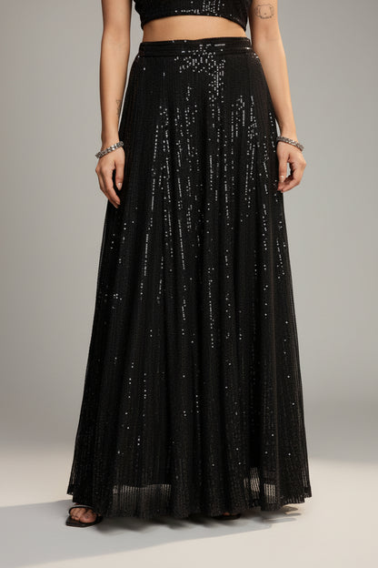Person wearing a black sequin skirt against a red background