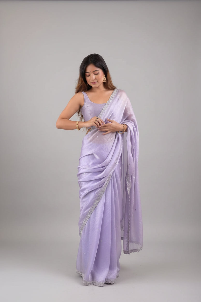 Woman wearing a light purple saree with a white background