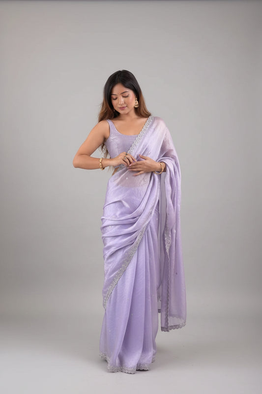Woman wearing a light purple saree with a white background