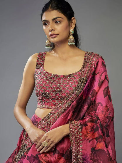 Woman wearing a pink traditional outfit with intricate designs on a gray background 